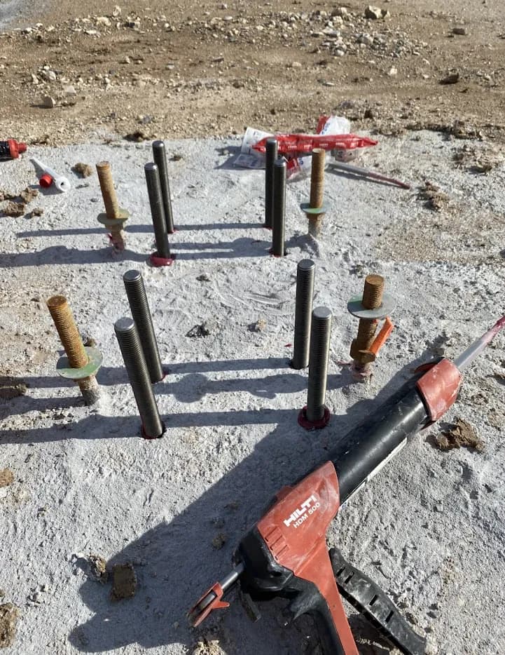 Varillas roscadas y anclajes en una base de concreto durante un trabajo de instalación